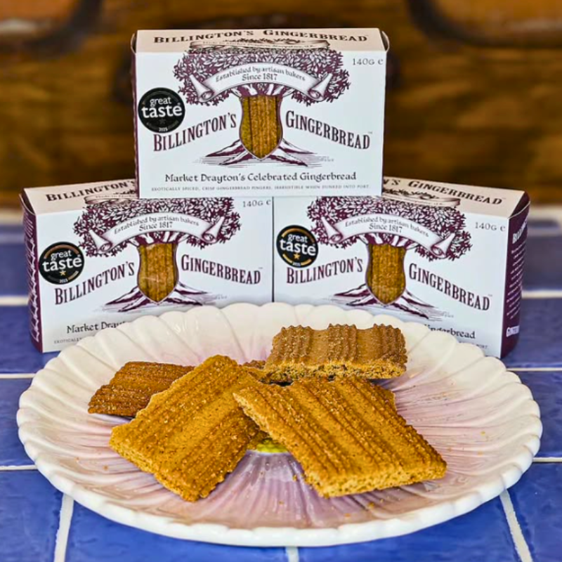 Billington’s Gingerbread boxes displayed behind a plate of traditional Market Drayton Billington's gingerbread fingers on a decorative dish.