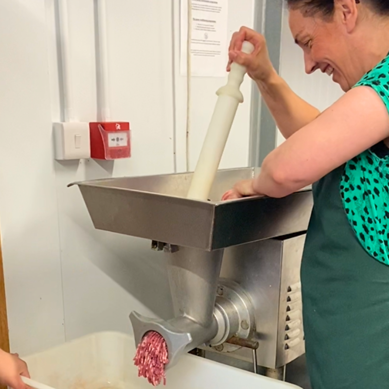 Pork being grinded in a mixer.