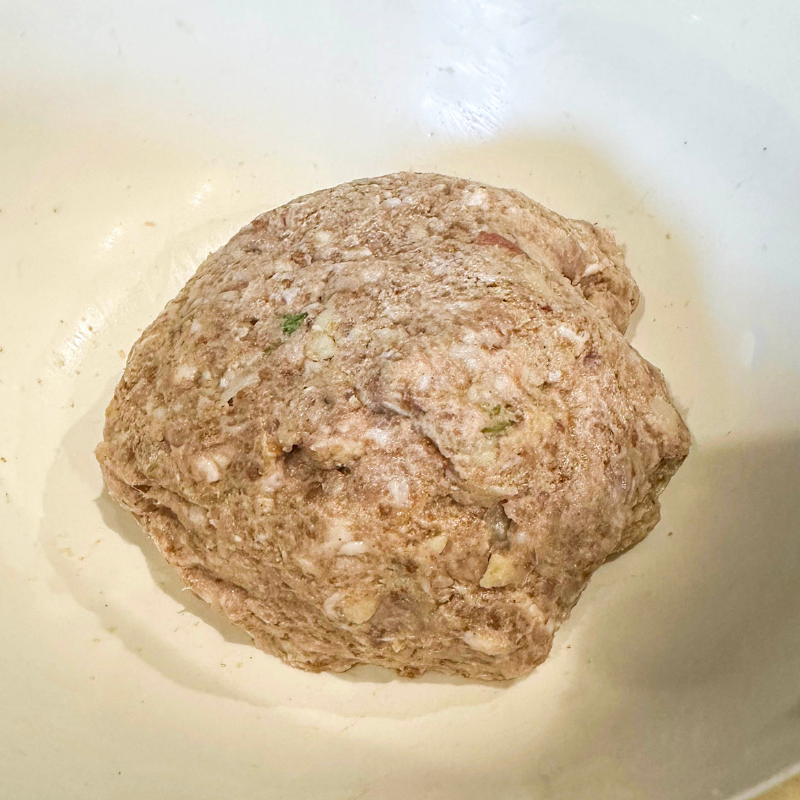 Sausage roll filling mixture with gingerbread, apple and ginger blended in mixing bowl ready for shaping