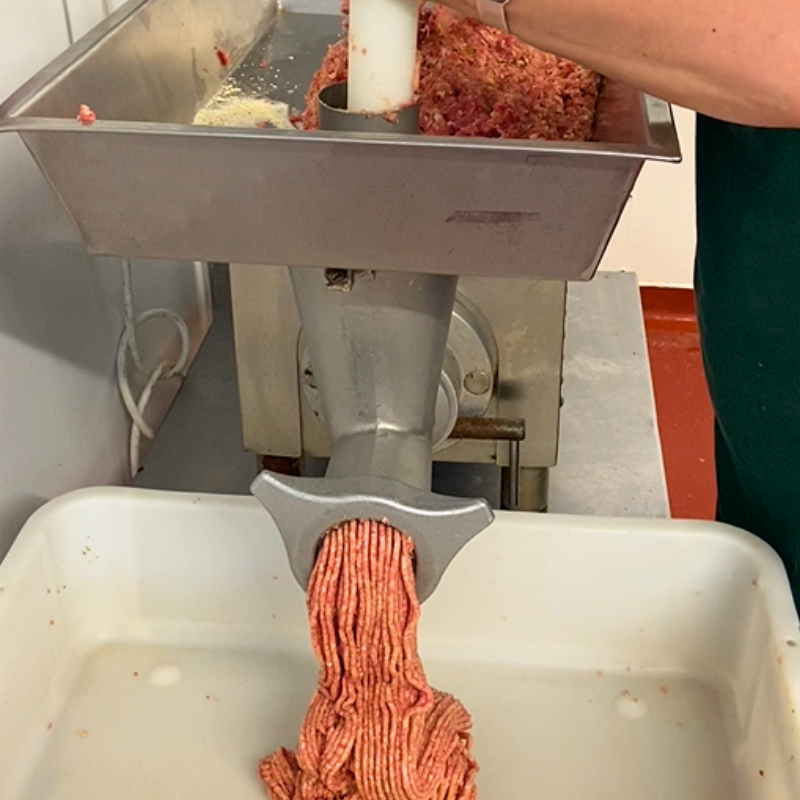 Pork being grinded in a mixer for sausages.