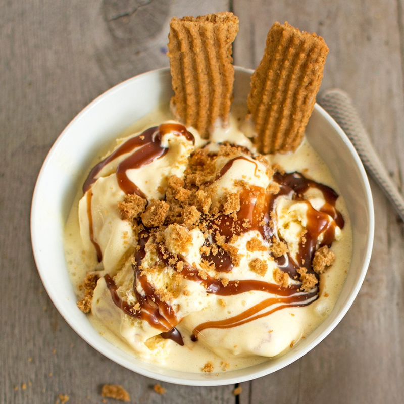 Vanilla ice cream topped with caramel sauce and crushed Billington's Gingerbread biscuits, served in a bowl with gingerbread fingers